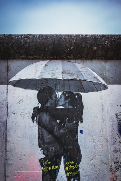男女在雨伞下接吻照片